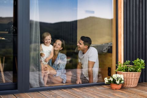Holzhaus Familienglück Familie hinter Glasterrassentür