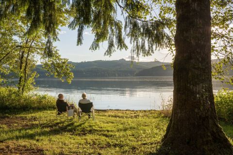 Holzhäuser für entspannte Senioren Seniorenpaar am Ufer eines Sees