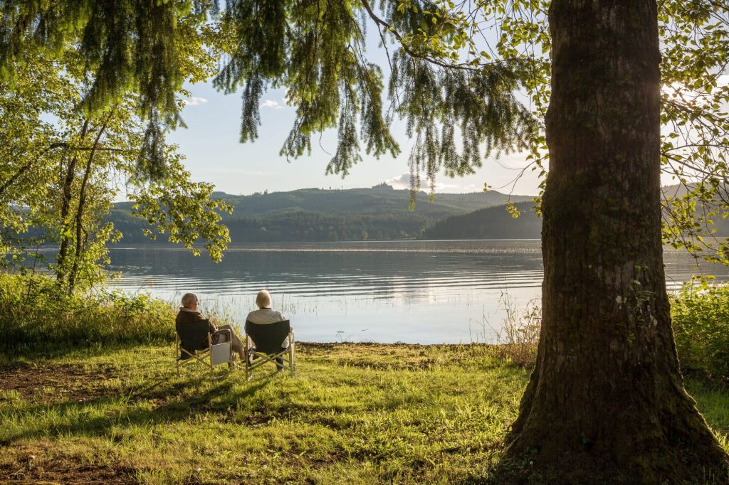 Holzhäuser für entspannte Senioren Seniorenpaar am Ufer eines Sees